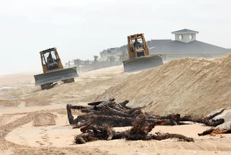 Dozers spread out sand to replenish the heavily eroded shoreline at Flagler Beach, Florida, U.S., January 26, 2018. Picture taken January 26, 2018. REUTERS/Gregg Newton