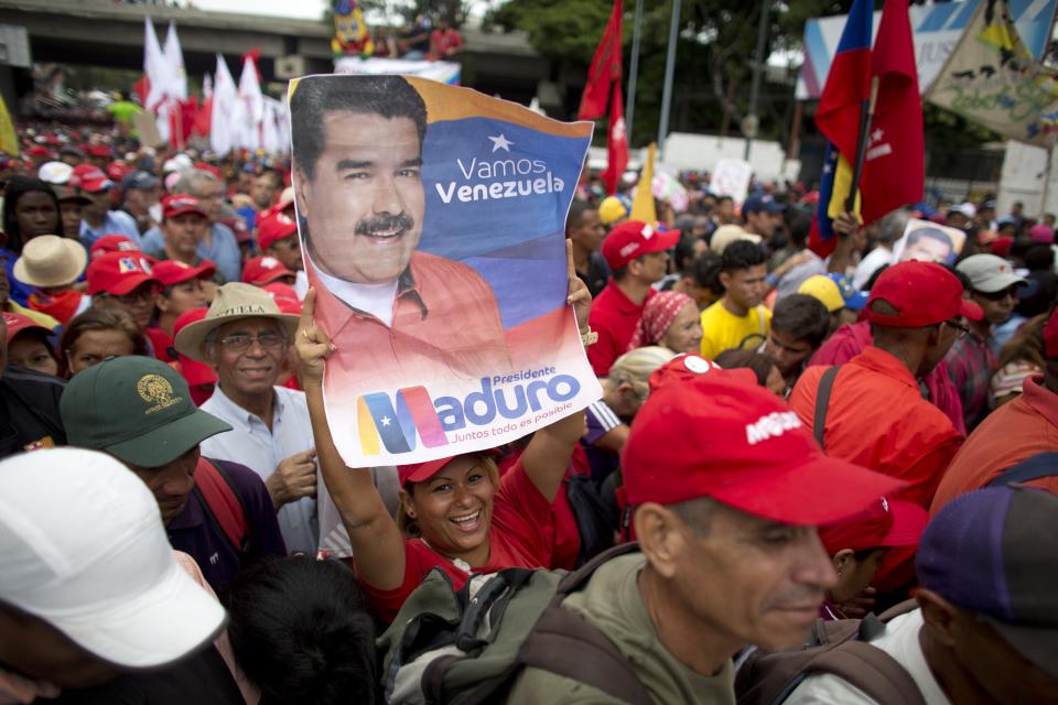 Un partidario del presidente de Venezuela, Nicolás Maduro, sostiene una imagen del mandatario durante un mitin en Caracas, Venezuela, el 13 de agosto de 2018. (AP Foto/Ariana Cubillos)