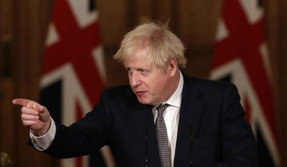 Britain's Prime Minister Boris Johnson gestures as he takes a question from the media during a news conference on the ongoing situation with the coronavirus pandemic, inside 10 Downing Street in London, Wednesday, Dec. 16, 2020. (AP Photo/Matt Dunham, Pool)