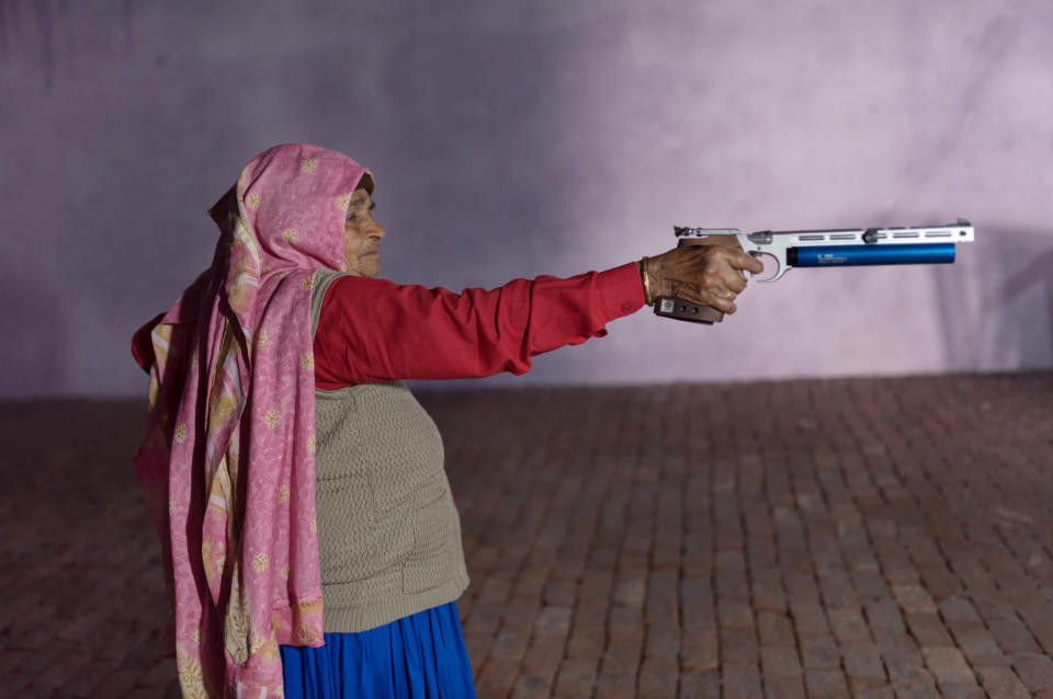 Chandro Tomar, de 89 años, practica con su pistola de aire comprimido en un campo que se está construyendo en su casa en la aldea de Johri, India, el 14 de febrero de 2021. (Smita Sharma/The New York Times)