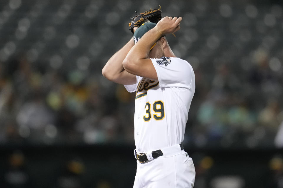 Oakland Athletics pitcher Kyle Muller reacts while waiting for pitching coach Scott Emerson to walk to the mound after Baltimore Orioles' Adley Rutschman hit a double during the fifth inning of a baseball game in Oakland, Calif., Friday, Aug. 18, 2023. (AP Photo/Jeff Chiu)