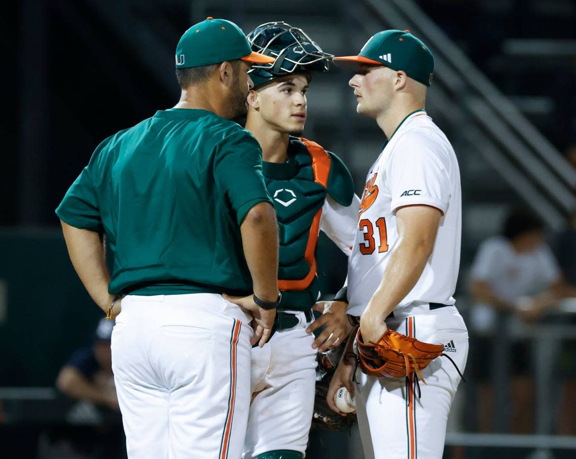 Miami Hurricanes catcher Carlos Perez (61) and pitching coach J.D Arteaga speak with starting pitcher Gage Ziehl (31) in the second inning against Penn State at Mark Light Field at Alex Rodriguez Park in Coral Gables, Florida on Friday, February 17, 2023. Al Diaz/adiaz@miamiherald.com