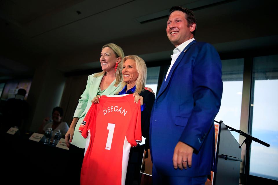 Mayor-elect Donna Deegan, center, holds up a jersey that was presented to her by President Amanda Vandervort of the USL Super League as Ricky Caplin, founder and chairman of Caplin Ventures, stand in for a photo opportunity during a press conference about the announcement of the city being part of the newly-formed women'sprofessional soccer organization, in Jacksonville, Fla.