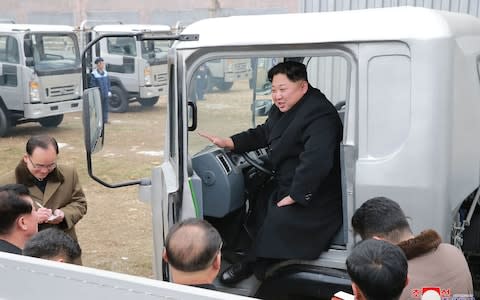 North Korean leader Kim Jong-un gets behind the wheel of a truck at the Sungri Motor Complex in South Pyongan Province - Credit: AFP