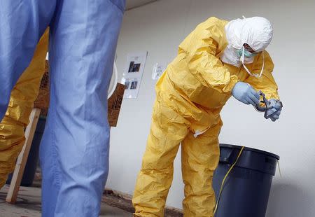 Registered nurse (RN) Sandy Sheble-Hall removes his goggles as per proper protocol directives given by Centers for Disease Control and Prevention (CDC) instructors in preparation for the response to the current Ebola outbreak, during a CDC safety training course in Anniston, Alabama, October 6, 2014. REUTERS/Tami Chappell