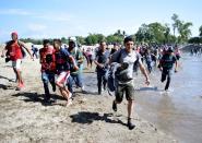 Migrants, part of a caravan travelling to the U.S, cross the Suchiate river from Tecun Uman, in Guatemala, to Ciudad Hidalgo