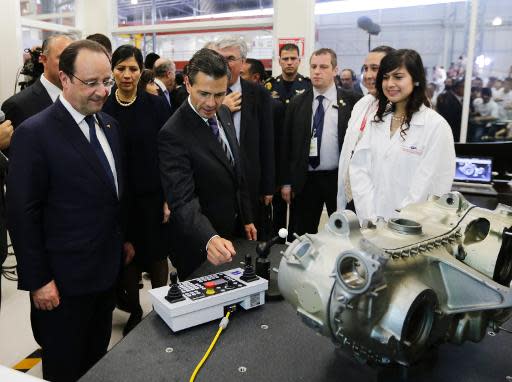 El presidente de Francia, François Hollande (I) junto a su par mexicano Enrique Peña Nieto (C) en una visita al Campus Franco Mexicano de la Universidad Aeronáutica, en Querétaro, México, el 11 de abril de 2014. (POOL/AFP | Henry Romero)