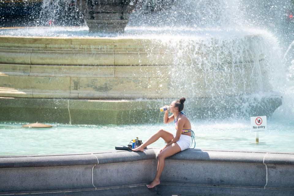 A woman sits by the fountains in Trafalgar Square, central London, as Britons are set to experience the hottest UK day on record as temperatures are predicted to hit 40C. Picture date: Tuesday July 19, 2022.