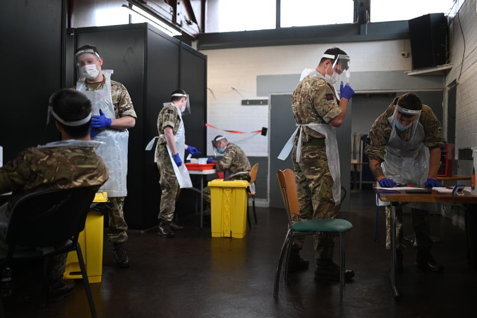 British Army soldiers, 1st battalion Coldstream Guards, staff a coronavirus testing centre set up at the Merseyside Caribbean Council Community Centre in Liverpool, north west England, on November 10, 2020 during a city-wide mass testing pilot operation. - Liverpool on November 6 began England's first city-wide trial of coronavirus testing in an attempt to prevent hospitals becoming overwhelmed during the country's second wave of the pandemic. All of the northwestern city's 500,000 residents as well as people working there will be offered repeat tests, even if asymptomatic, under the pilot trial, which will initially run for two weeks. (Photo by Oli SCARFF / AFP) (Photo by OLI SCARFF/AFP via Getty Images)