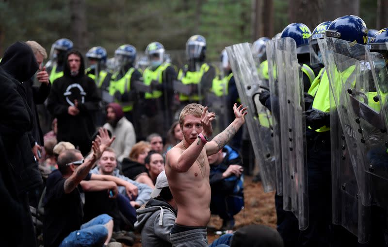 A reveller puts his hands up in front of riot police at the scene of a suspected illegal rave in Thetford Forest