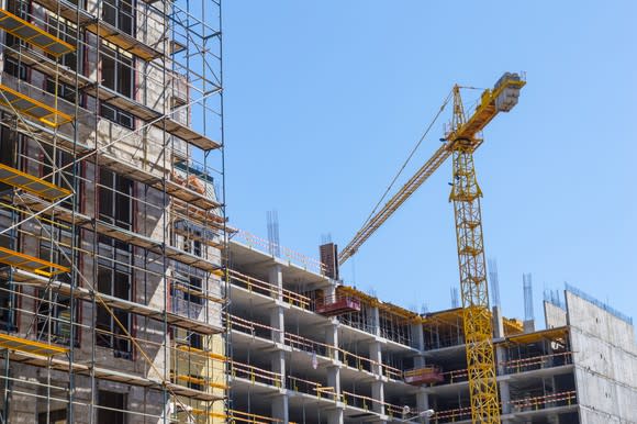 A giant construction crane helping to build a tall building.