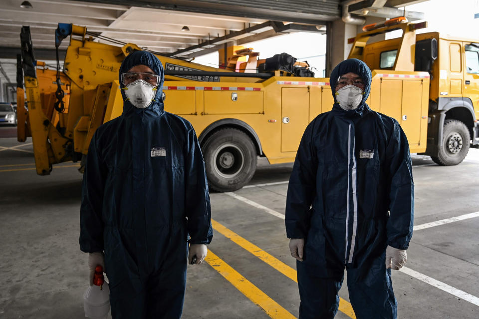 Image: Workers wearing protective gear prepare to disinfect a bus as part of measures against of the COVID-19 coronavirus in Shanghai (Hector Retamal / AFP - Getty Images)