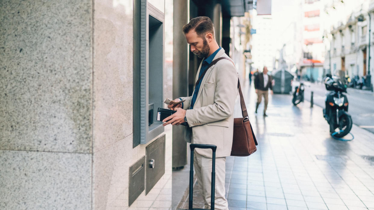 Businessman withdrawing money from ATM.