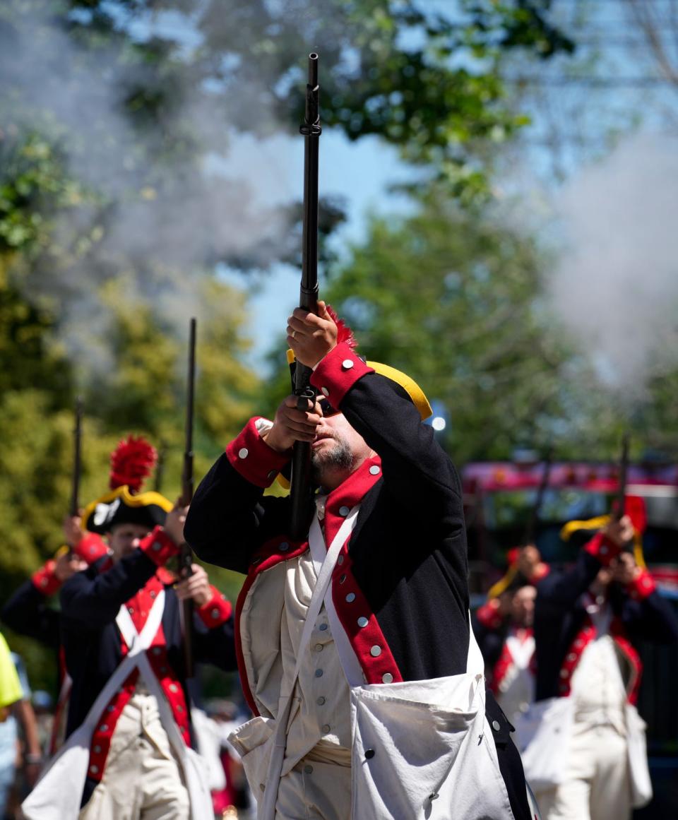 Mike Souza and other members of the Historic RI Militia, Bristol Train of Artillery, fire a musket salute during the Bristol Fourth of July parade in 2022.