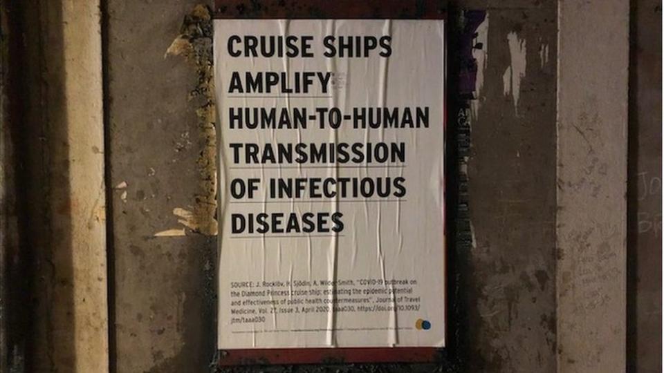 Poster stuck to a wall saying "cruise ships amplify transmission of infectious diseases"
