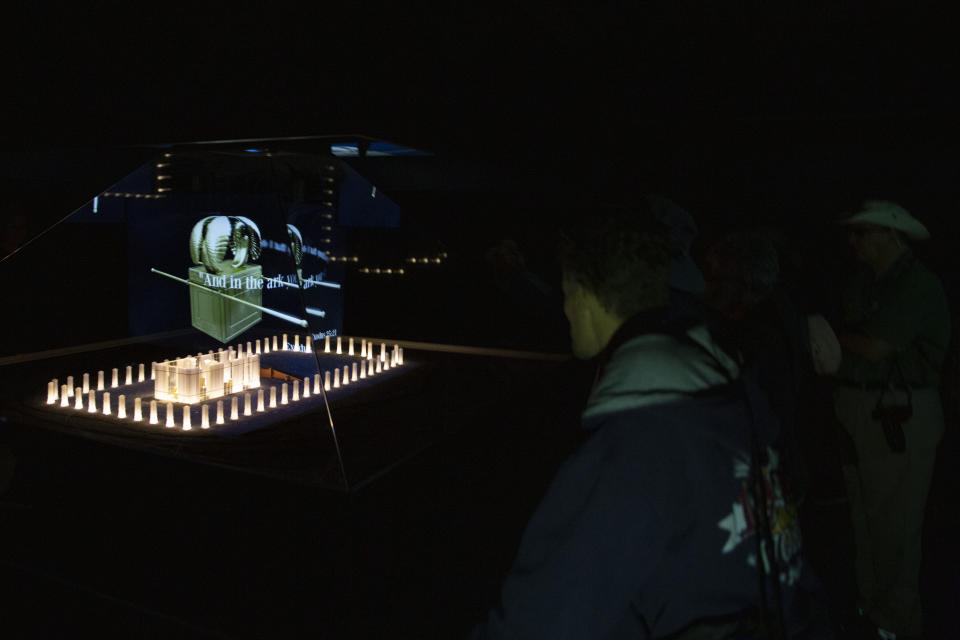 In this Tuesday, March 12, 2019 photo, tourists look at a hologram at the archaeological site of Tel Shiloh in the West Bank. Deep in the West Bank, an Israeli settlement has transformed the archaeological site into a biblical tourist attraction that is drawing tens of thousands of Evangelical Christian visitors each year. Critics say the site promotes a narrow interpretation of history popular with Israeli settlers and their Christian supporters. (AP Photo/Sebastian Scheiner)