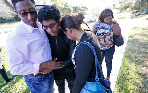 Family members embrace after a student walked out from Marjory Stoneman Douglas High School