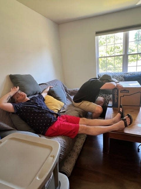 Matthew Hambleton, left, and his husband Kevin Lowrie, take a break after spending Saturday in the sweltering heat moving into their new suburban Philadelphia home.