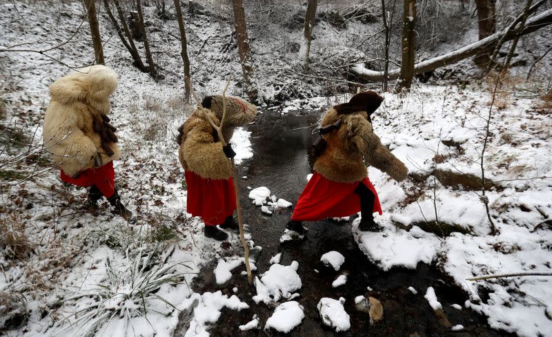 Revellers dressed as devils walk through the village of Valasska Polanka