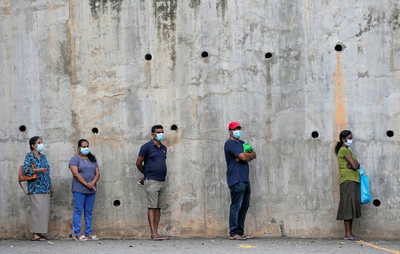 People maintain the one-meter distance in-between each other as they stand in a line to buy groceries at a supermarket during the time government lifted the curfew in Colombo