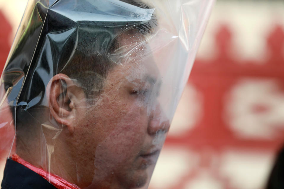 A man wears a plastic bag on his head during an environmental activists' rally to demand rights to clean air, near the Thai Government House in Bangkok