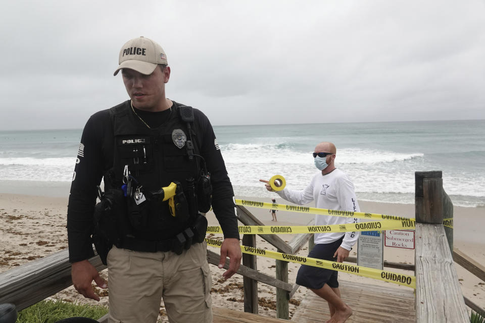 Police and lifeguards from the Town of Lantana close the beach and boardwalk, Sunday, Aug. 2, 2020, as Tropical Storm Isaias brushes past the East Coast of Florida. (Joe Cavaretta/South Florida Sun-Sentinel via AP)