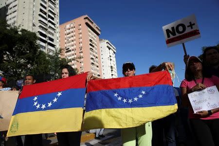 Opposition supporters holding Venezuelan national flags, up side down, take part in a protest against Venezuelan President Nicolas Maduro's government in Caracas, Venezuela March 31, 2017. REUTERS/Carlos Garcia Rawlins/Files