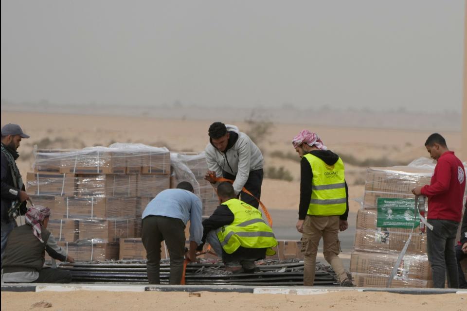 Workers receive humanitarian aid from Saudi Arabia, at Al Arish airport, Egypt, on its way to Gaza, Sunday, Nov. 19, 2023.