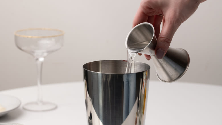 pouring tequila into cocktail shaker 