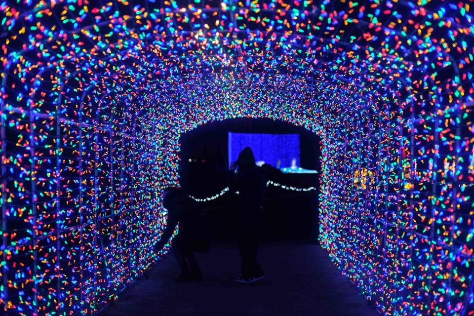A couple admires the tunnel of Christmas lights at Maxwell's Magical Christmas in Amarillo.