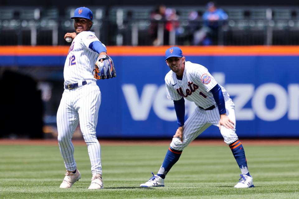 The New York Mets' Francisco Lindor (12) warms up as Jeff McNeil (1) stretches before the start of a baseball game against the Arizona Diamondbacks, Sunday, April 17, 2022 in New York.