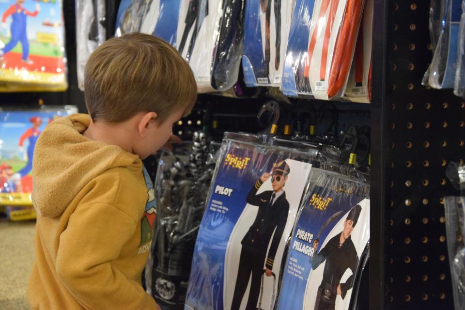 Cooper Wilp, 3, looks through his costume options at Spirit Halloween on Oct. 11, 2023. He wants to dress as a pirate this Halloween.