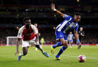 Porto's Wendell, right, and Arsenal's Bukayo Saka battle for the ball during the Champions League round of 16, second leg soccer match between Arsenal and Porto at the Emirates Stadium, London, Tuesday March 12, 2024. (Zac Goodwin/PA via AP)