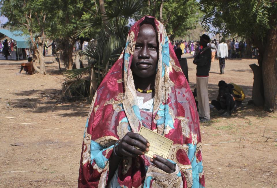 In this photo taken Tuesday, April 1, 2014, a South Sudanese woman poses with her World Food Programme (WFP) card which she uses to receive food and other aid, in Nyal, Unity State, South Sudan. Desperate South Sudan villagers, fleeing fighting across the country, are eating grass and roots to survive as WFP starts costly air drops of food, three times more expensive than road deliveries, to northern parts of the country, straining the ramped-up humanitarian response because only a third of the U.N.'s requested $1.27 billion has been raised for the crisis. (AP Photo/Ilya Gridneff)