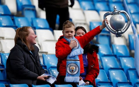 A fan inside the stadium holds up an inflatable balloon trophy - Credit: ACTION IMAGES