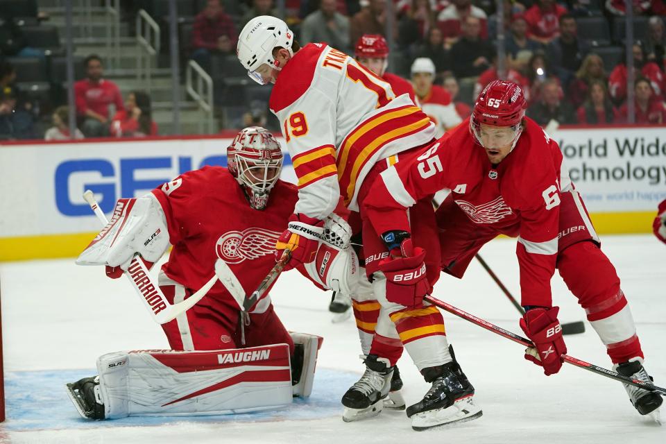 Detroit Red Wings goaltender Alex Nedeljkovic (39) stops a Calgary Flames left wing Matthew Tkachuk (19) shot as Danny DeKeyser (65) defends in the first period of an NHL hockey game Thursday, Oct. 21, 2021, in Detroit.