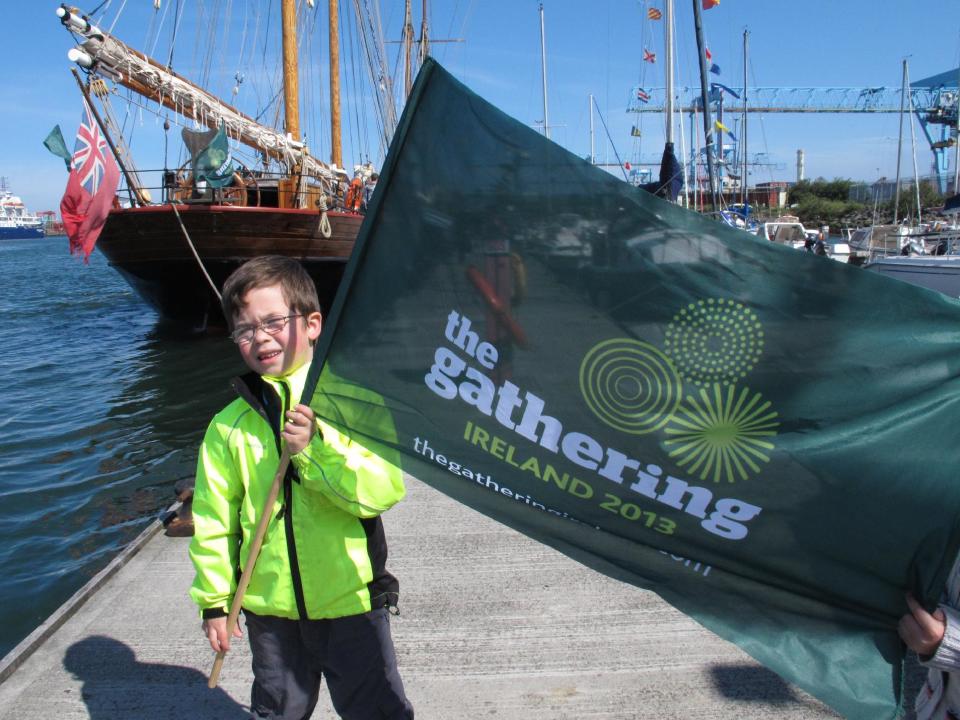 This May 17, 2013 photo shows 5-year-old Callum MacCobb posing with his flag on Dublin docks as he greeted the tall ships sailing into the port. The ships were replicas of vessels that once carried millions of emigrants away from Ireland to seek their fortune elsewhere. The event was part of The Gathering, a yearlong tourism initiative to boost Ireland's economy by luring its diaspora home. (AP Photo/Helen O'Neill)