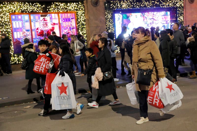 FILE PHOTO: People carry shopping bags from Macy's Herald Square during early opening for the Black Friday sales in Manhattan, New York City