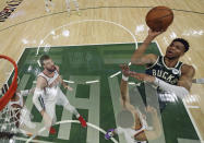 Milwaukee Bucks' Giannis Antetokounmpo (34) shoots over Phoenix Suns' Devin Booker in Game 3 of basketball's NBA Finals, Sunday, July 11, 2021, in Milwaukee. (Jonathan Daniel/Pool Photo via AP)