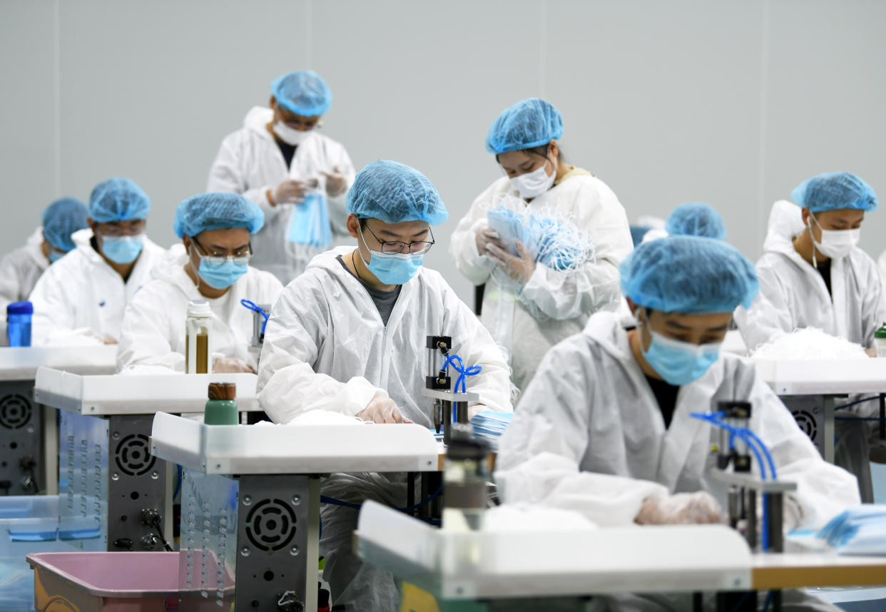 Employees work on a production line of surgical masks for export, at a railway equipment manufacturing company in Nanchang, Jiangxi province, China April 8, 2020. Picture taken April 8, 2020. (China Daily via Reuters)