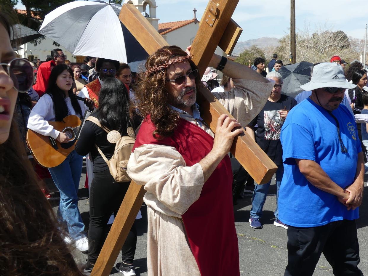 Hundreds of Good Friday worshipers observed the Stations of the Cross outside of St. Joan of Arc Catholic Church in Victorville.