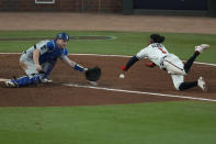 Los Angeles Dodgers catcher Will Smith can not make the tag on Atlanta Braves Ozzie Albies scores on a single by Austin Riley in the eighth inning in Game 2 of baseball's National League Championship Series Sunday, Oct. 17, 2021, in Atlanta. (AP Photo/John Bazemore)