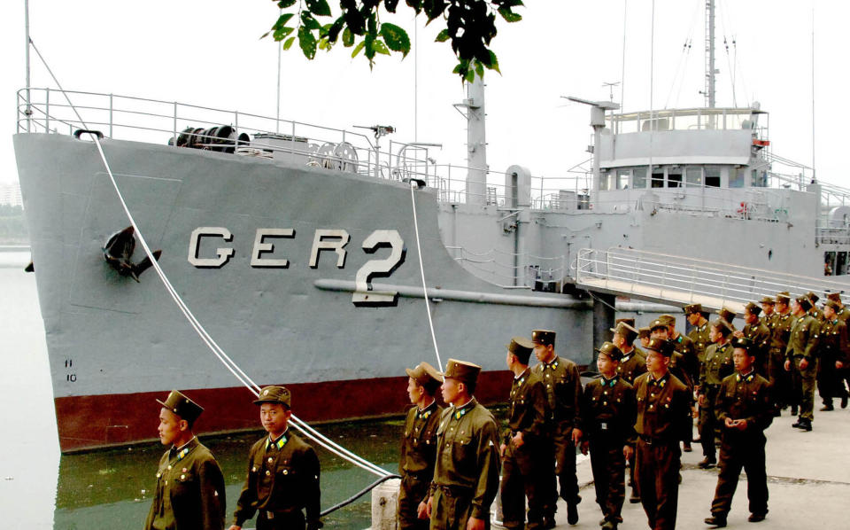 North Korean soldiers watch USS Pueblo, which was seized by North Korean navy off the Korean coast near Taedonggang river in Pyongyang, in a photo dated June 22, 2006.
