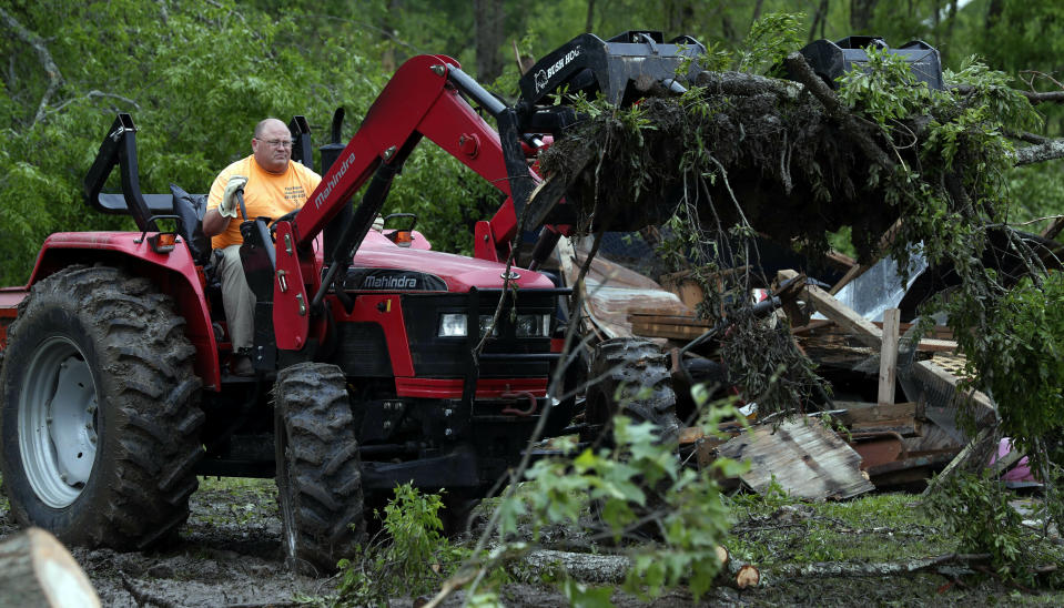 A farm tractor is used to remove debris from a tornado damaged home, Friday, April 19, 2019, in Morton, Miss., as residents begin their cleanup from Thursday's possible tornado touchdown that heavily damaged many homes. (AP Photo/Rogelio V. Solis)