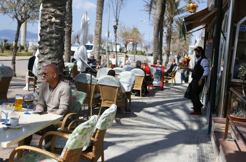 Christian, Uruguayan waiter and co-owner of the terrace bar "Zu Krone" serves German customers in Playa de Palma beach