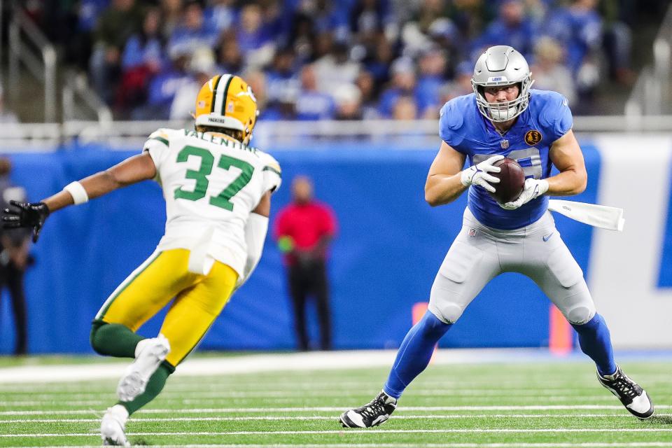 Detroit Lions tight end Brock Wright makes a catch against Green Bay Packers cornerback Carrington Valentine during the first half at Ford Field in Detroit on Thursday, Nov. 23, 2023.