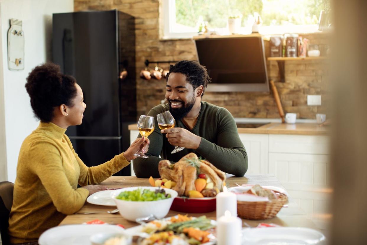 happy couple toasting during thanksgiving meal in dining room