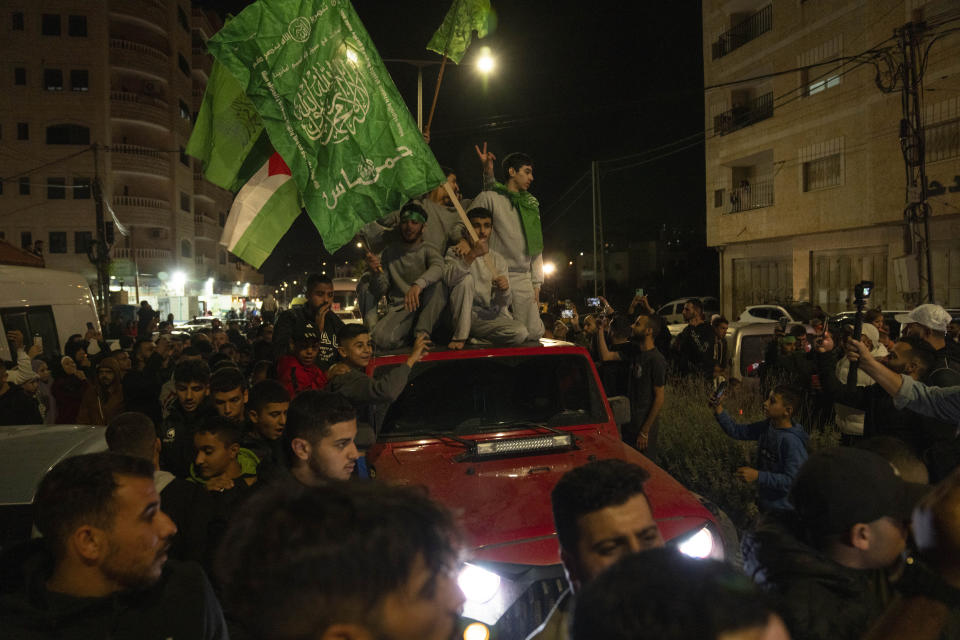 Former Palestinian prisoners who were released by the Israeli authorities, fly Palestinian and Hamas flags while they ride on top of a vehicle upon their arrival in the West Bank town of Beitunia, Friday, Nov. 24, 2023. The release came on the first day of a four-day cease-fire deal between Israel and Hamas during which the Gaza militants have pledged to release 50 hostages in exchange for 150 Palestinians imprisoned by Israel. (AP Photo/Nasser Nasser)