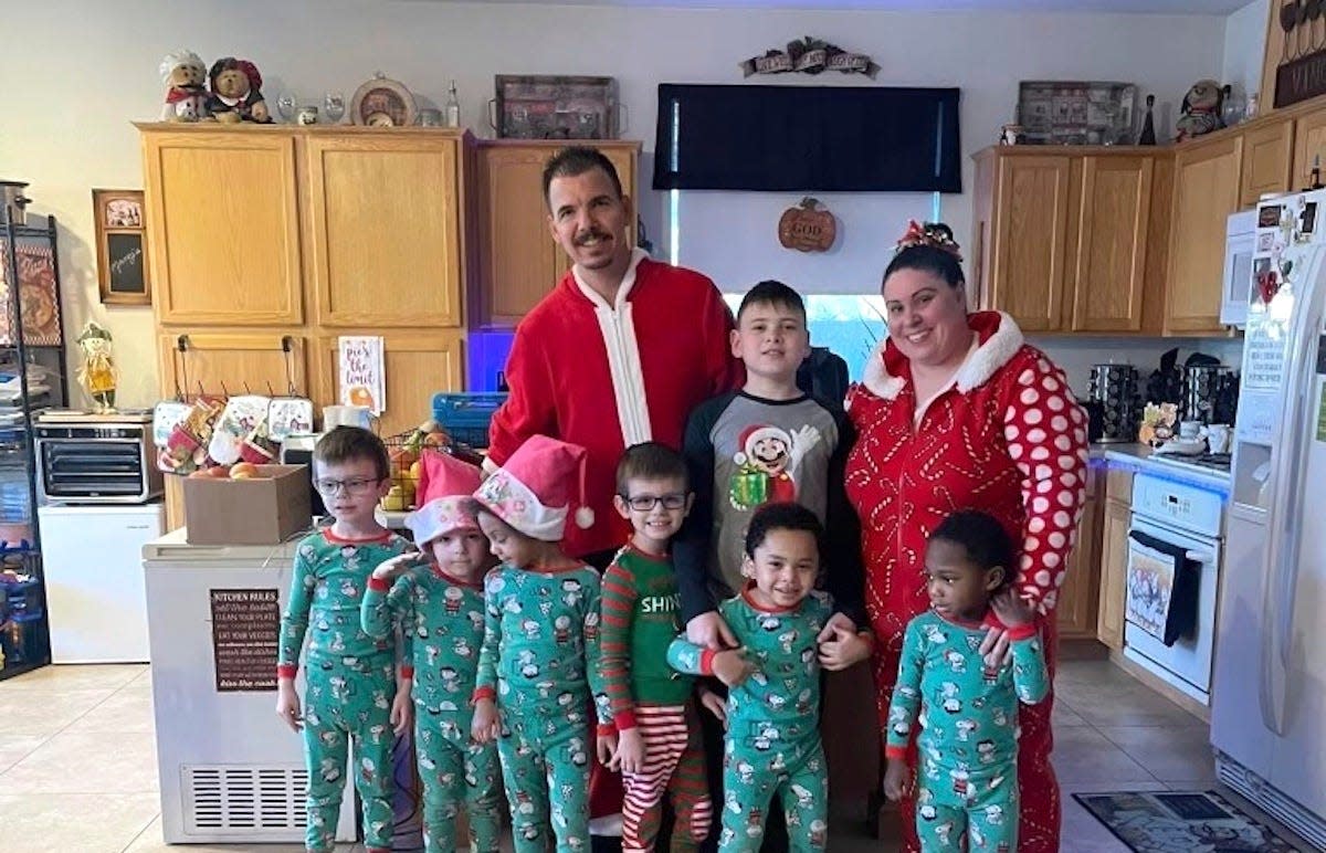 In this photo provided by Karen Lopez, she and her husband, Jerry Lopez, are seen with their seven children in December 2023. Jerry Lopez, 39, was killed in Las Vegas two days after Christmas while on his way to work in what Las Vegas police say was the final carjacking in a crime spree. (Karen Lopez via AP)