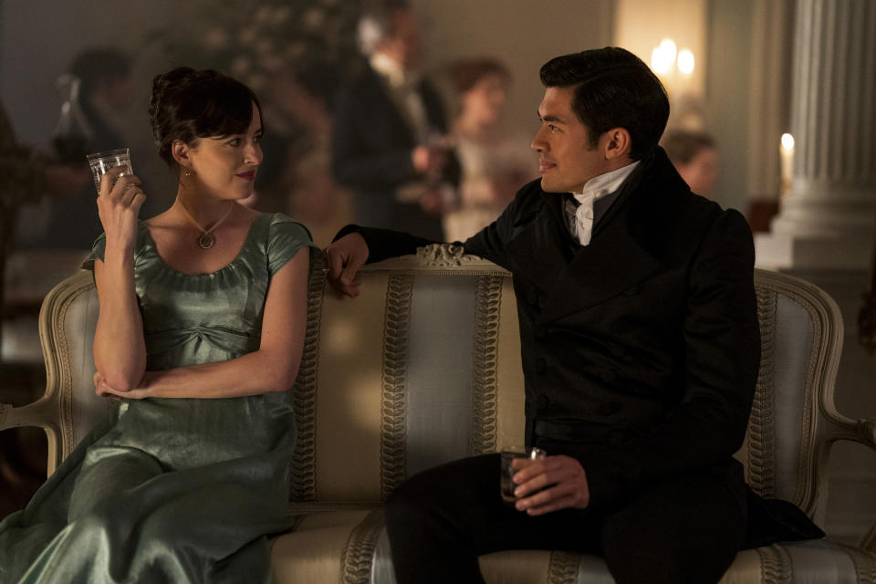 This image released by Netflix shows Dakota Johnson, left, and Henry Golding in a scene from "Persuasion." (Nick Wall/Netflix via AP)